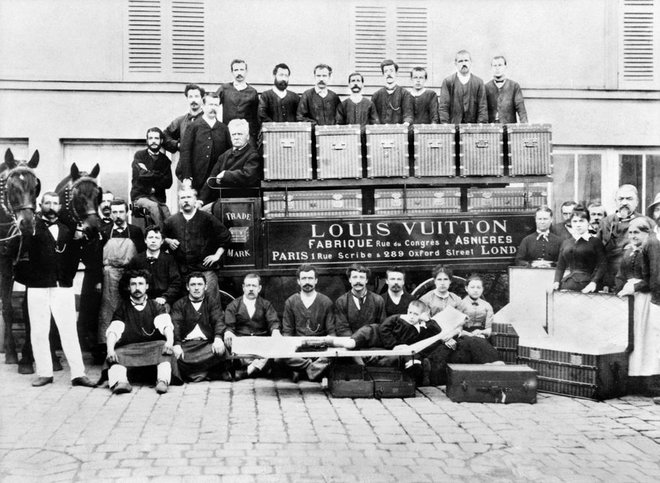 Louis Vuitton okrog leta 1888, na sliki z ekipo delavcev pred delavnico v Asnieresu. Na fotografiji sta tudi Vuittonov sin Georges in vnuk Gaston Louis, ki leži na postelji spredaj.
